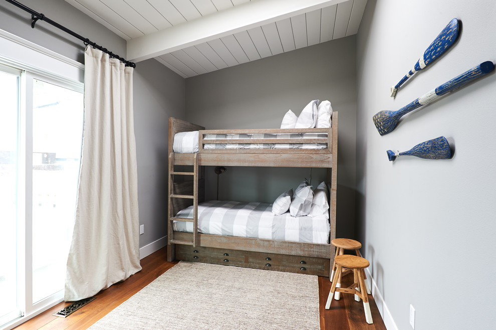 Bild på ett litet lantligt könsneutralt barnrum kombinerat med sovrum och för 4-10-åringar, med grå väggar, mellanmörkt trägolv och brunt golv