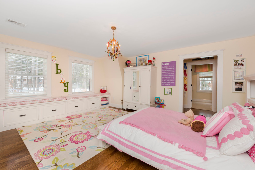 Diseño de dormitorio infantil clásico con paredes beige y suelo de madera oscura