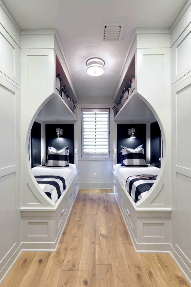 Foto di una piccola cameretta per bambini chic con pareti bianche, parquet chiaro e pavimento marrone