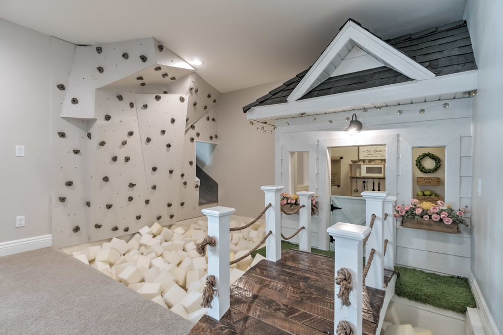 Bild på ett lantligt barnrum kombinerat med lekrum, med grå väggar, heltäckningsmatta och grått golv