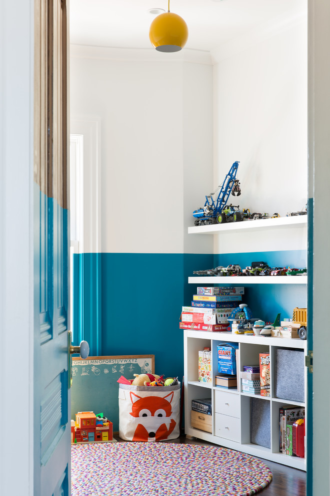 Exempel på ett stort eklektiskt könsneutralt barnrum kombinerat med lekrum och för 4-10-åringar, med blå väggar, mörkt trägolv och brunt golv