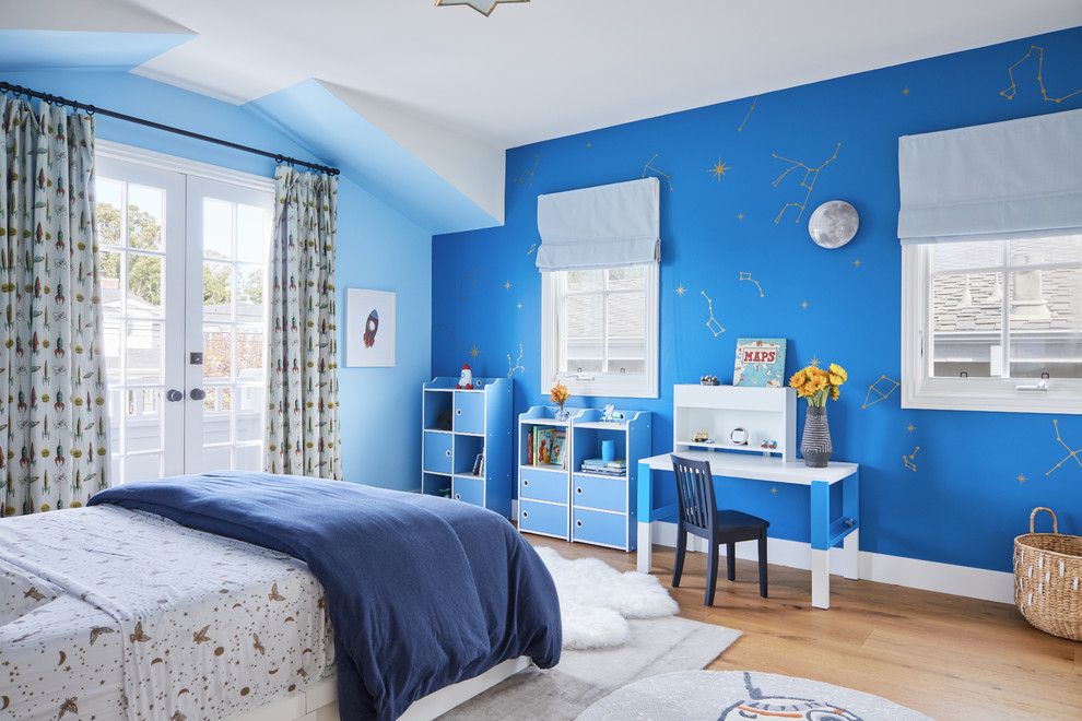Ejemplo de dormitorio infantil de 4 a 10 años costero con paredes azules y suelo de madera clara