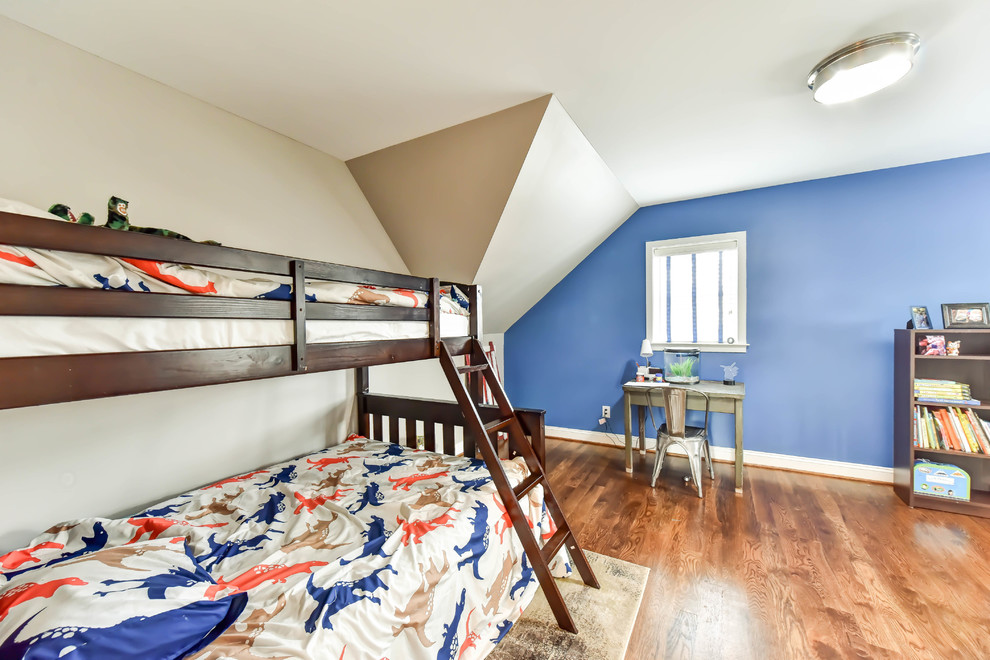 This is an example of a medium sized classic children’s room for boys with blue walls, medium hardwood flooring and brown floors.