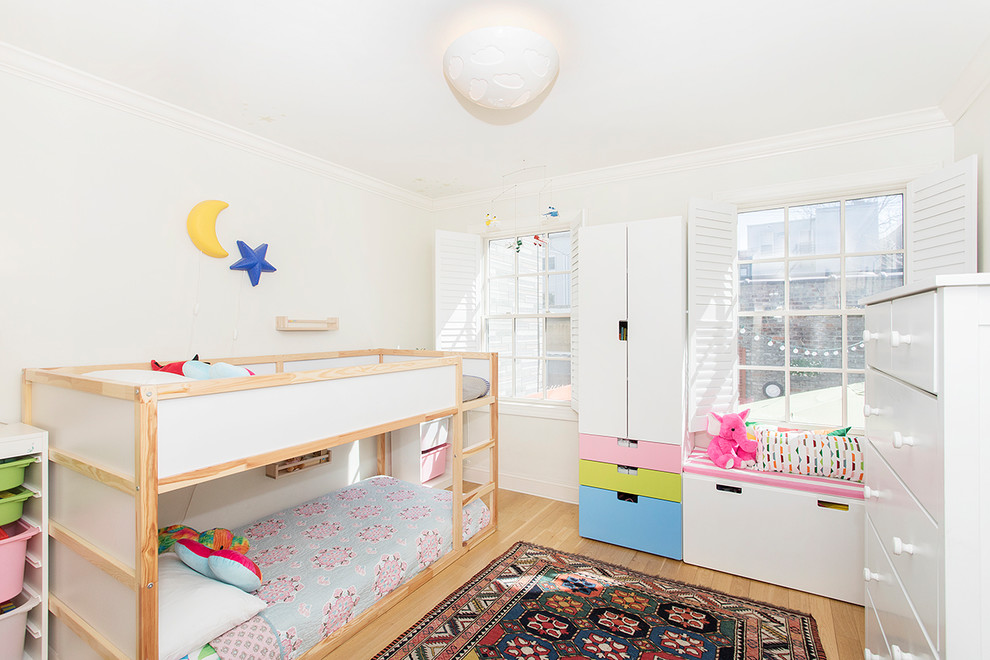 Bild på ett mellanstort funkis barnrum kombinerat med sovrum, med vita väggar, ljust trägolv och brunt golv