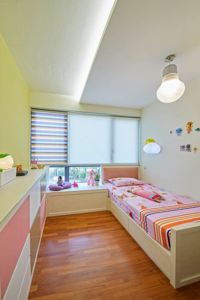 Idée de décoration pour une chambre d'enfant design de taille moyenne avec un sol en contreplaqué et un mur multicolore.