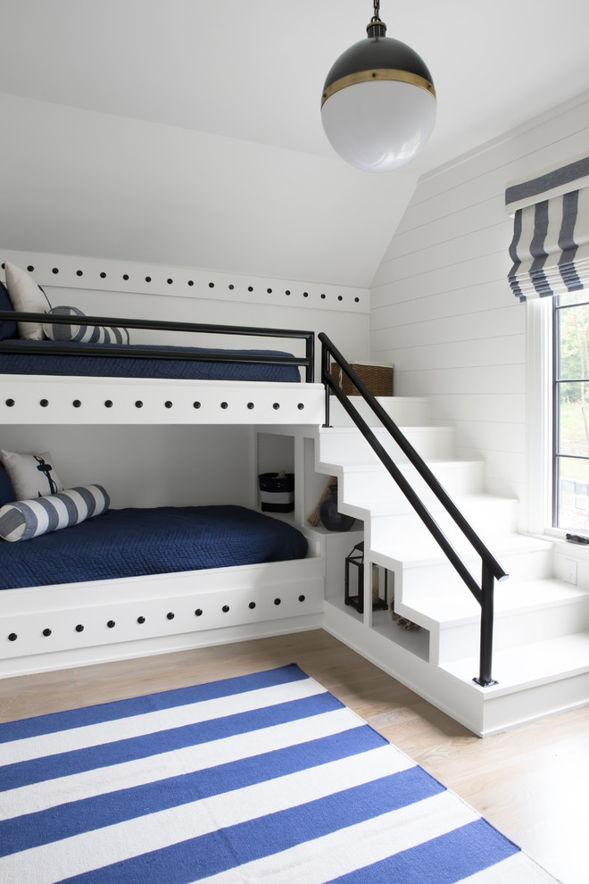 Modelo de dormitorio infantil marinero con paredes blancas, suelo de madera clara y suelo beige