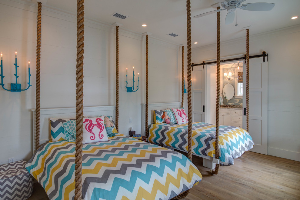 Photo of a nautical teen’s room for girls in Miami with white walls and light hardwood flooring.