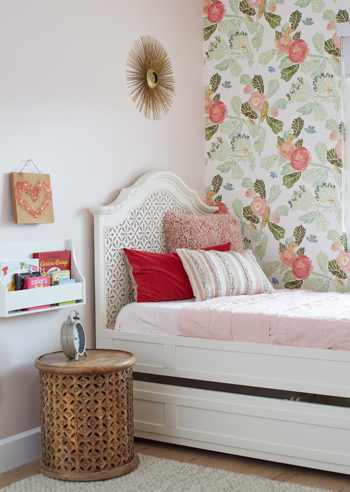 This is an example of a medium sized vintage children’s room for girls in Phoenix with grey walls, light hardwood flooring and beige floors.