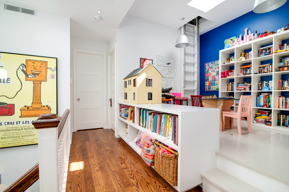 Medium sized contemporary gender neutral kids' bedroom in New York with blue walls, medium hardwood flooring and brown floors.