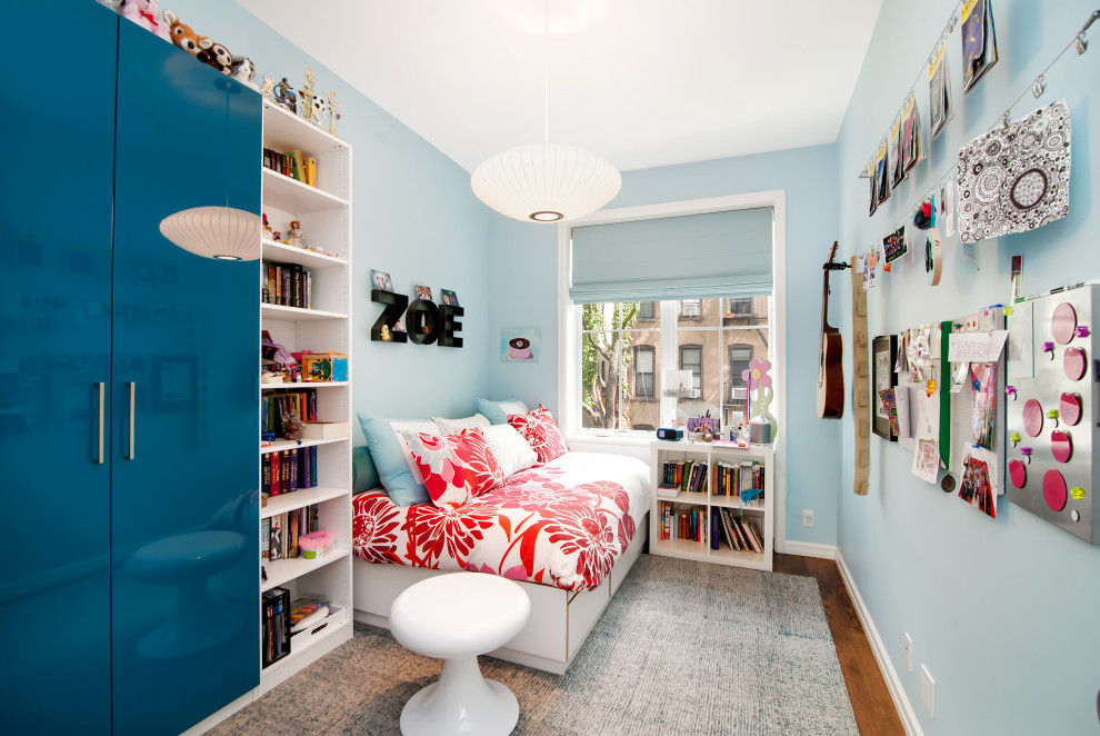 Esempio di una cameretta per bambini minimal di medie dimensioni con pareti blu, pavimento in legno massello medio e pavimento marrone