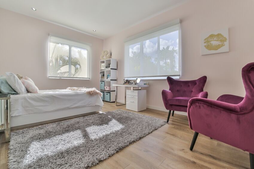 Ejemplo de dormitorio infantil actual con paredes rosas y suelo de madera clara