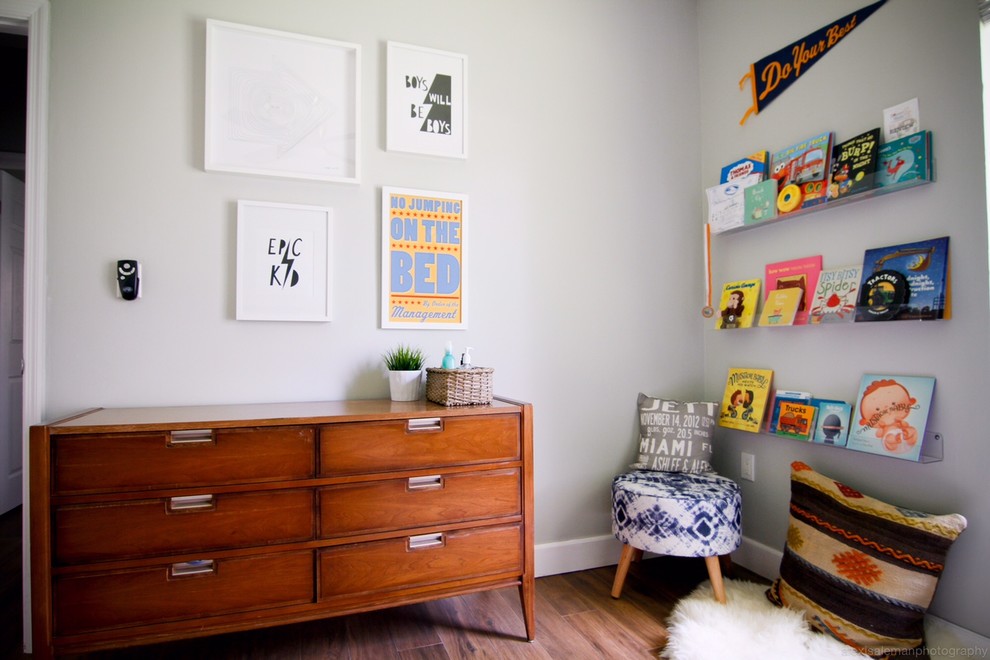 Esempio di una cameretta per bambini da 1 a 3 anni minimalista di medie dimensioni con pareti grigie e parquet scuro