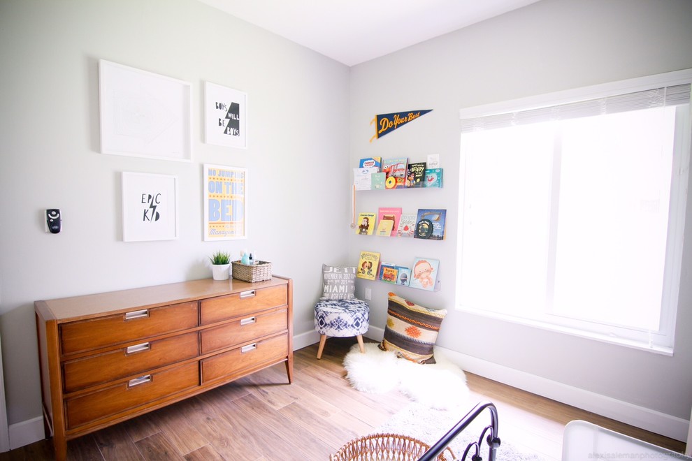 Cette image montre une chambre d'enfant de 1 à 3 ans vintage de taille moyenne avec un mur gris et parquet foncé.