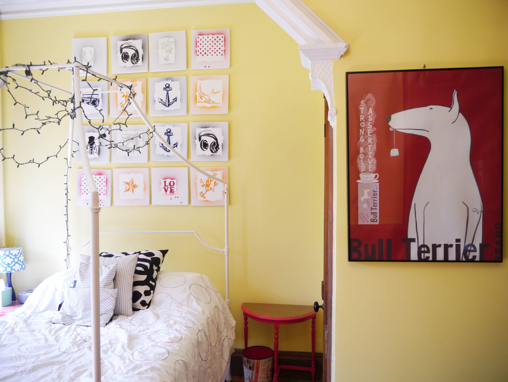 Idées déco pour une grande chambre d'enfant contemporaine avec un mur jaune et un sol en bois brun.