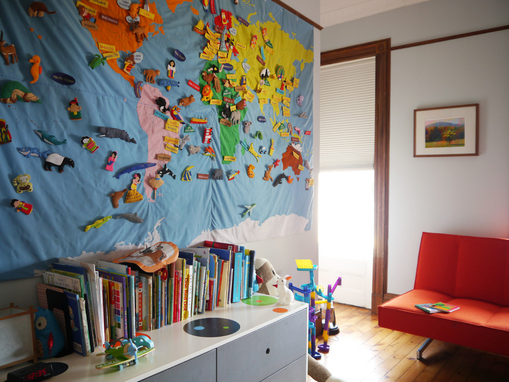 Immagine di una cameretta per bambini da 4 a 10 anni contemporanea di medie dimensioni con pareti bianche e pavimento in legno massello medio