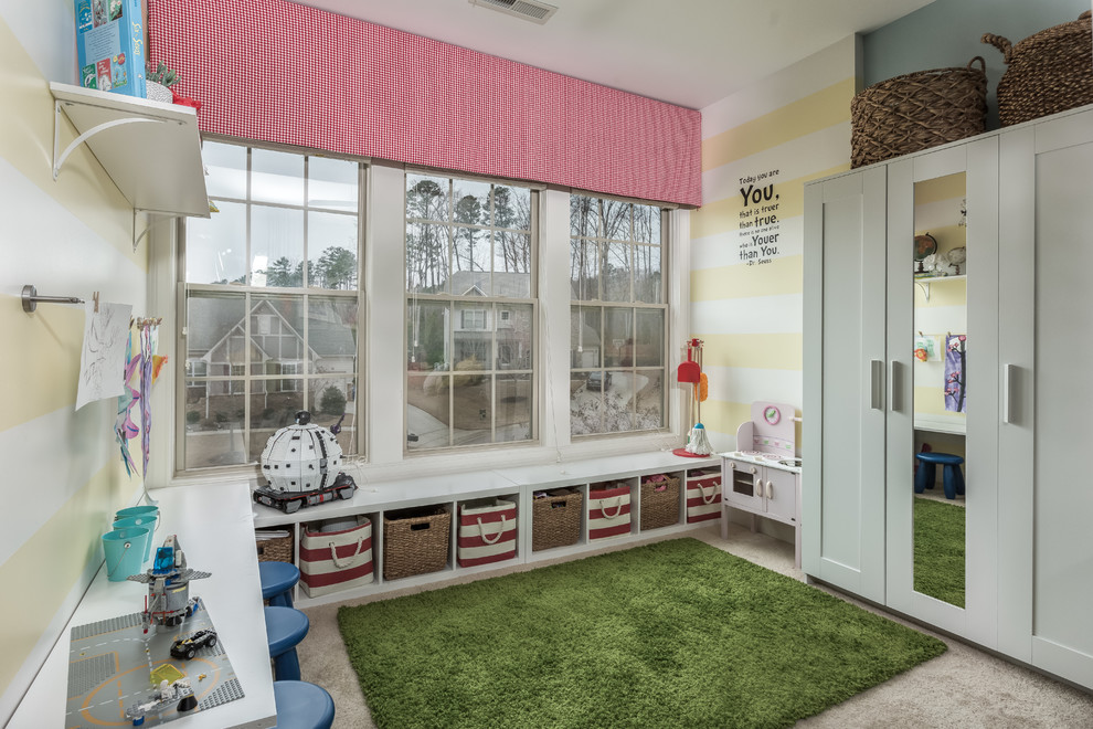 Klassisk inredning av ett mellanstort könsneutralt barnrum kombinerat med lekrum och för 4-10-åringar, med gröna väggar, heltäckningsmatta och beiget golv