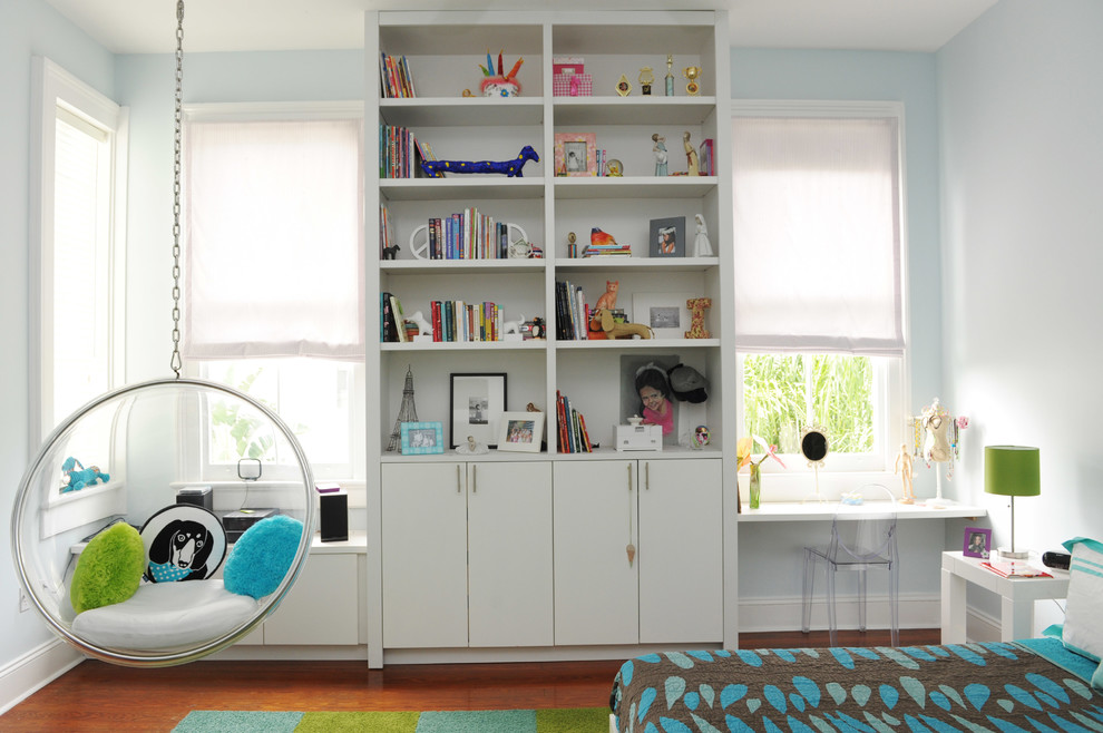 Idéer för ett modernt barnrum kombinerat med sovrum, med blå väggar och mellanmörkt trägolv