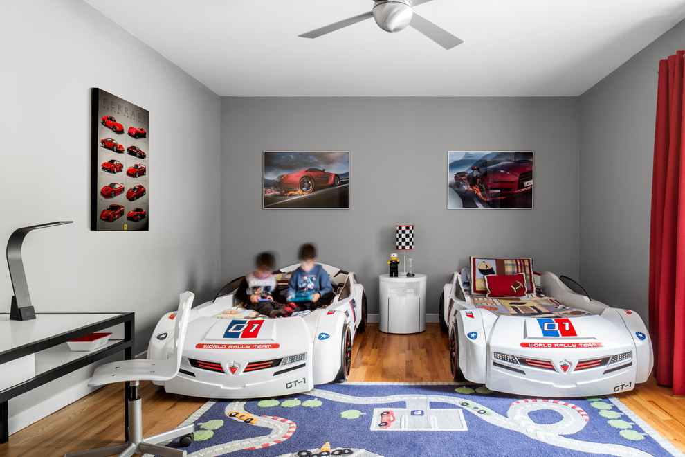 На фото: детская в современном стиле с спальным местом, серыми стенами и паркетным полом среднего тона для ребенка от 4 до 10 лет, мальчика с
