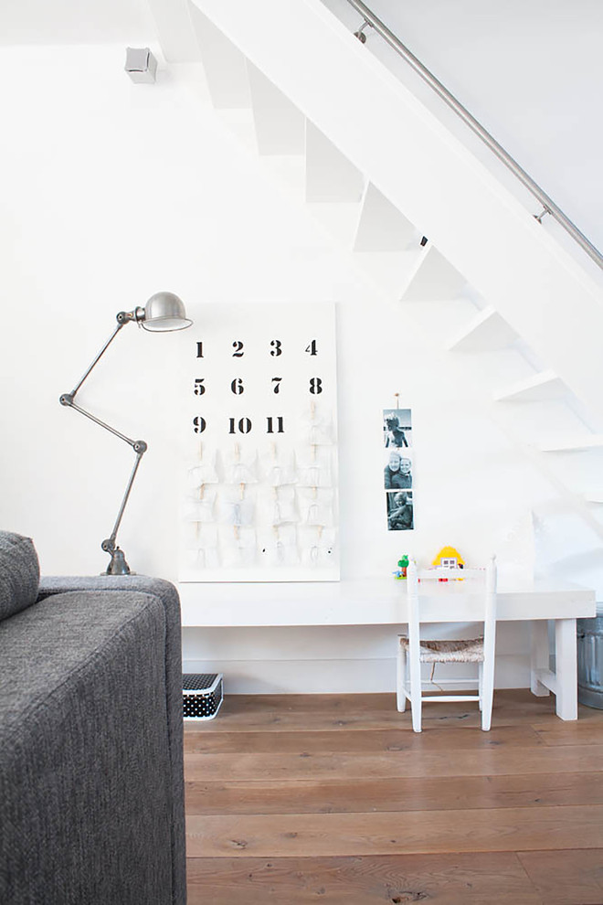 Design ideas for a bohemian gender neutral kids' study space in Amsterdam with white walls and light hardwood flooring.