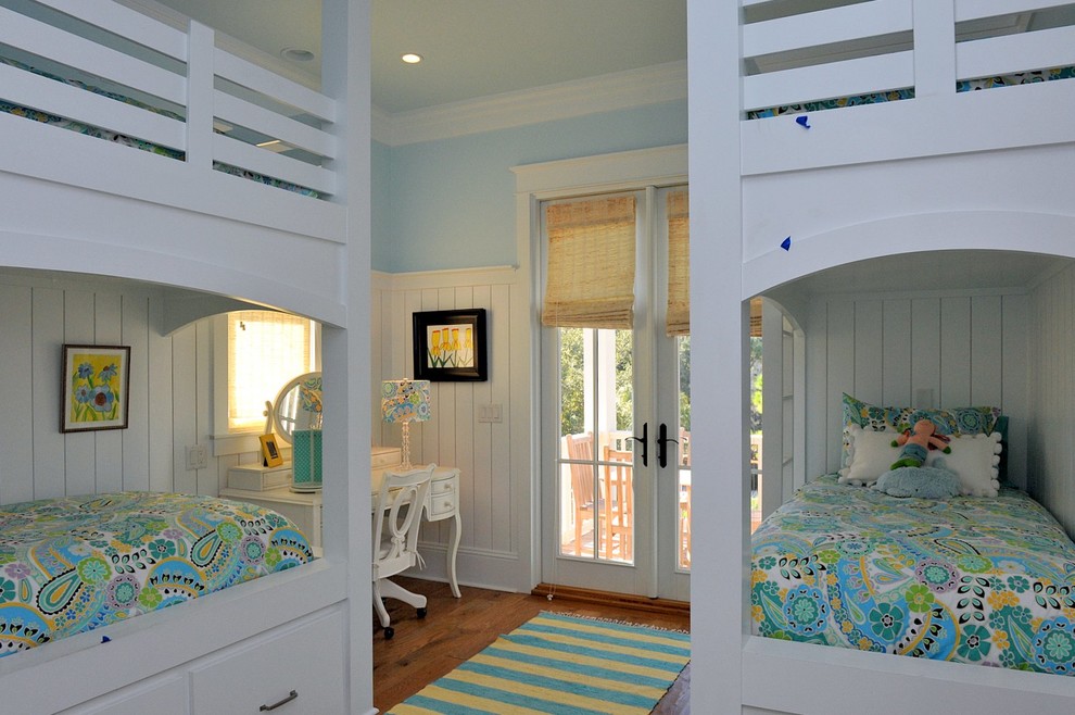 Modelo de dormitorio infantil de 4 a 10 años costero de tamaño medio con paredes azules y suelo de madera en tonos medios