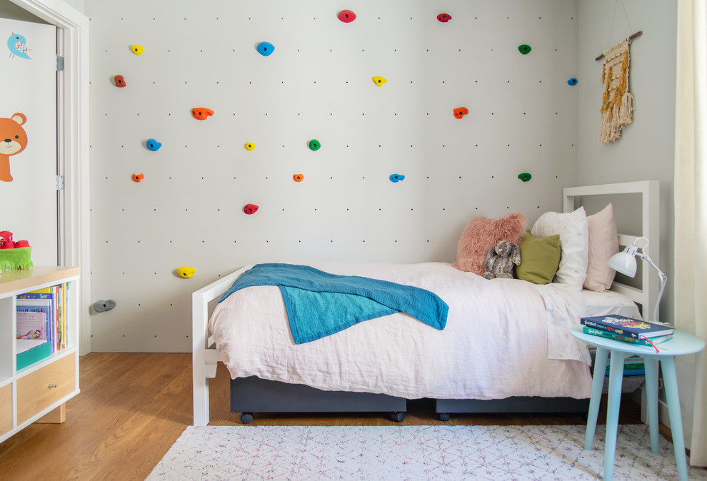 Aménagement d'une chambre d'enfant de 4 à 10 ans contemporaine de taille moyenne avec un mur blanc, un sol en bois brun et un sol marron.