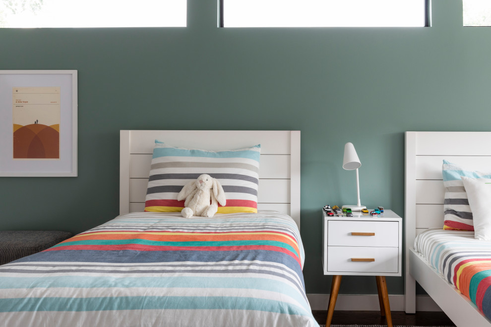 Modelo de dormitorio infantil actual de tamaño medio con paredes blancas, suelo de madera en tonos medios, suelo marrón y papel pintado
