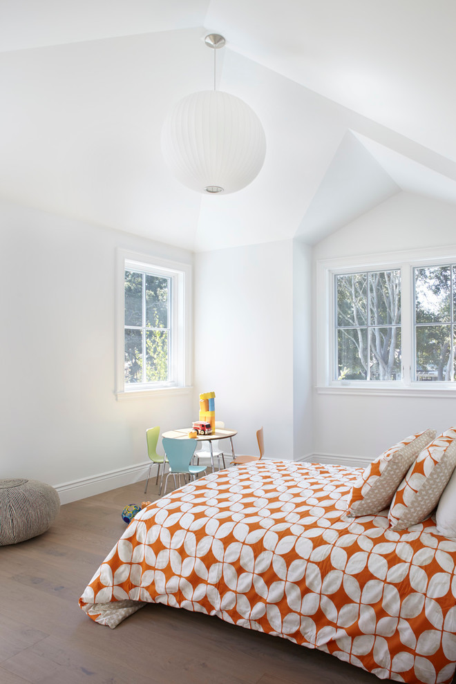 This is an example of a contemporary gender neutral kids' bedroom in San Francisco with white walls and light hardwood flooring.