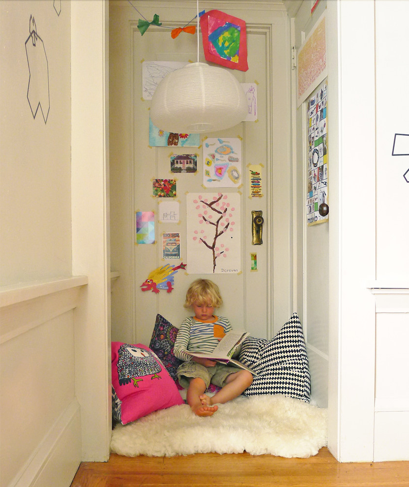 Esempio di una cameretta per bambini eclettica con pareti grigie e pavimento in legno massello medio