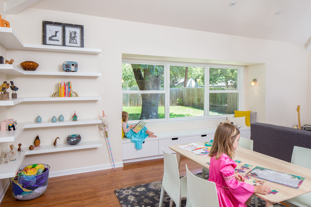Immagine di una cameretta per bambini da 4 a 10 anni design di medie dimensioni con pareti bianche e pavimento in legno massello medio