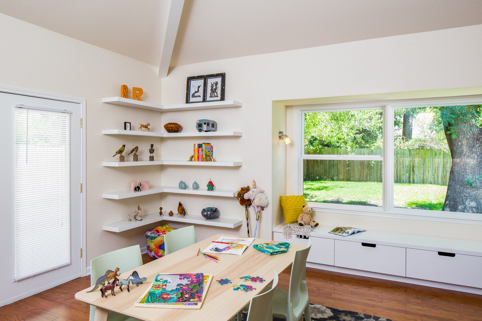 Foto på ett mellanstort funkis könsneutralt barnrum kombinerat med skrivbord och för 4-10-åringar, med vita väggar och mellanmörkt trägolv