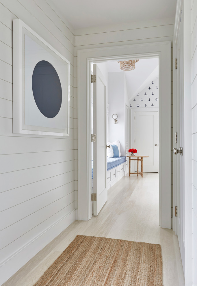 Huge trendy gender-neutral light wood floor kids' room photo in New York with white walls