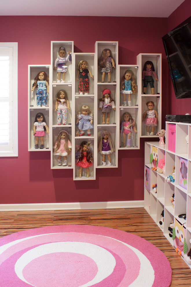 Modelo de dormitorio infantil de 4 a 10 años actual de tamaño medio con paredes rosas y suelo de madera en tonos medios