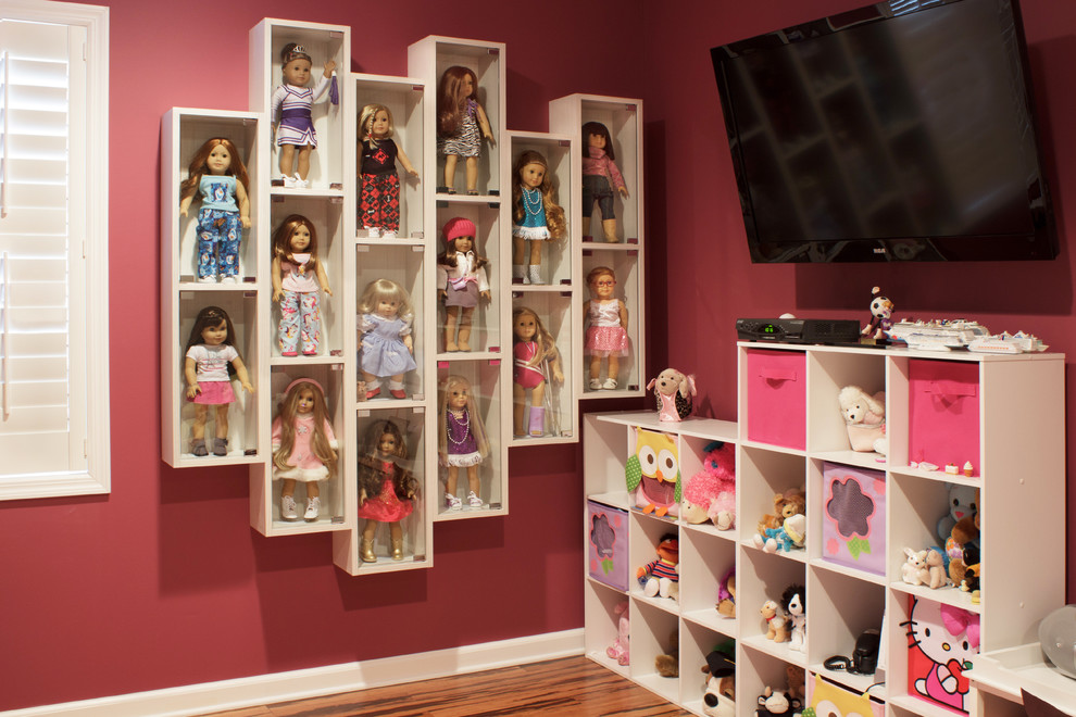 Cette photo montre une chambre d'enfant de 4 à 10 ans tendance de taille moyenne avec un mur rose et un sol en bois brun.