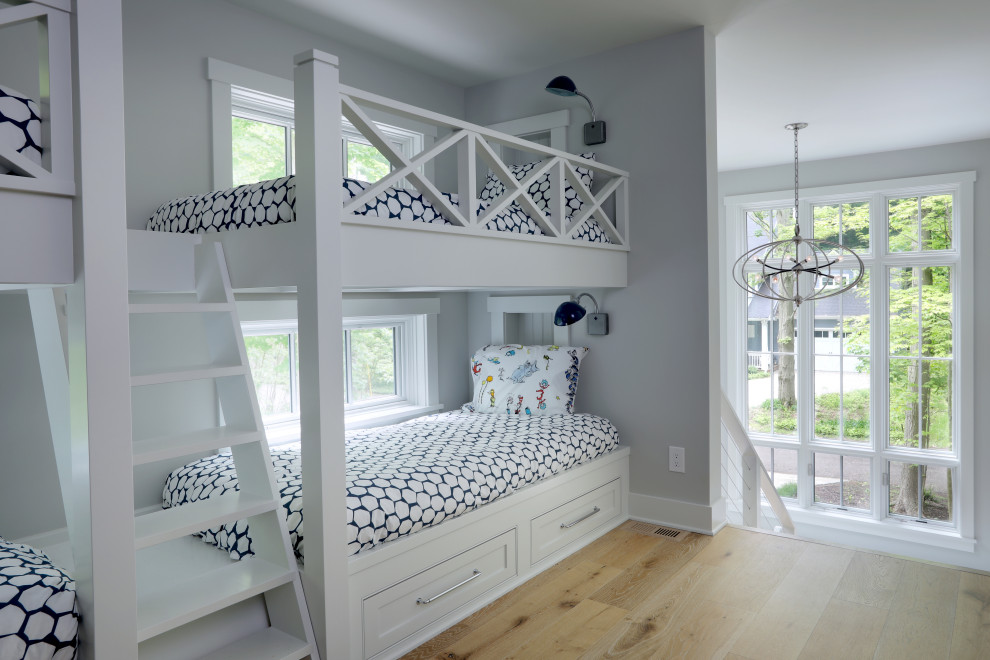 Diseño de habitación infantil unisex de 4 a 10 años clásica renovada de tamaño medio con paredes grises, suelo de madera clara y suelo beige