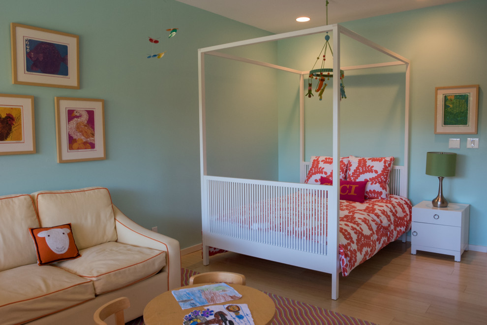 Immagine di una cameretta per bambini da 4 a 10 anni eclettica di medie dimensioni con parquet chiaro e pareti blu