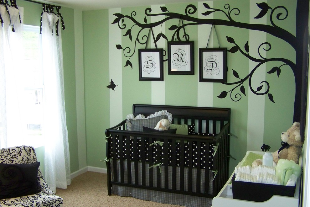 Immagine di una cameretta per neonati chic con pareti verdi