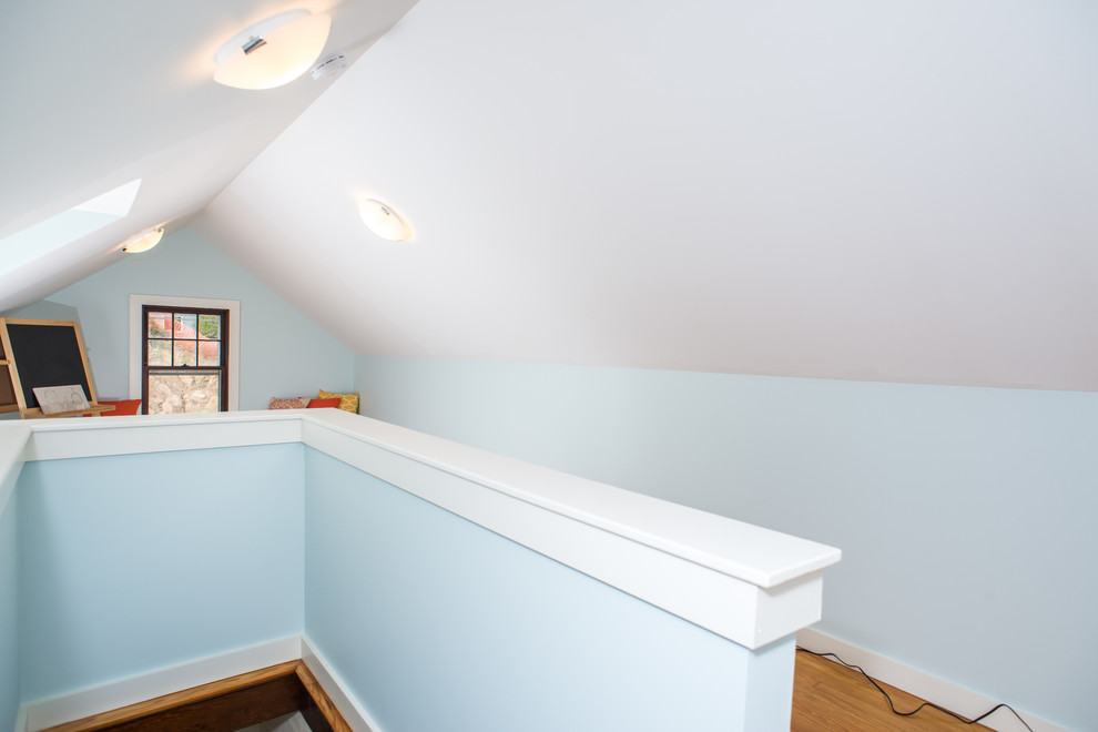 Foto di una cameretta per bambini da 4 a 10 anni tradizionale con pareti blu e pavimento in legno massello medio