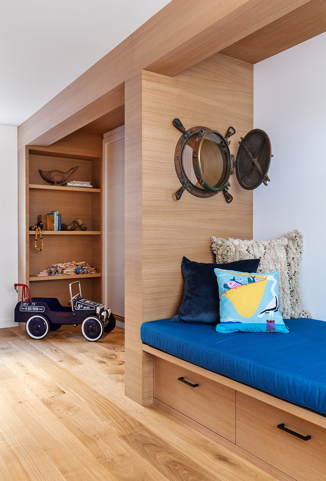 Imagen de dormitorio infantil marinero con paredes blancas y suelo de madera clara