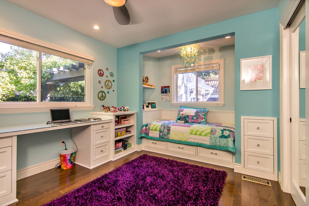 Foto på ett litet vintage flickrum kombinerat med sovrum och för 4-10-åringar, med blå väggar och mellanmörkt trägolv