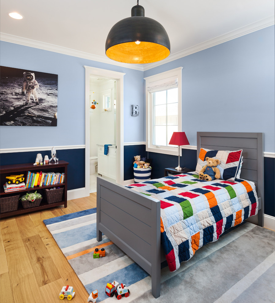 This is an example of a classic toddler’s room for boys in Phoenix with blue walls, light hardwood flooring, beige floors and a dado rail.