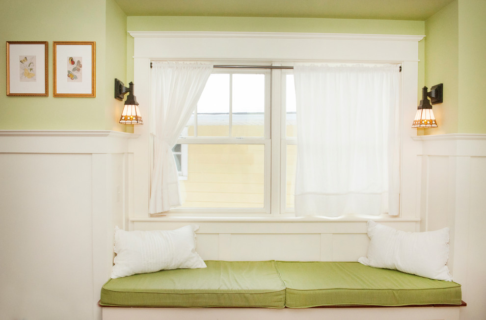 Immagine di una cameretta per bambini da 1 a 3 anni american style di medie dimensioni con pareti verdi e pavimento in legno massello medio