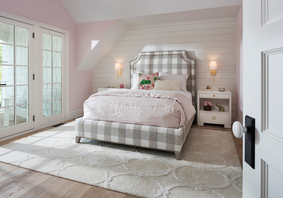 Photo of a beach style children’s room for girls in Minneapolis with pink walls and light hardwood flooring.