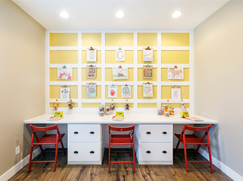 Bild på ett mellanstort vintage könsneutralt barnrum för 4-10-åringar och kombinerat med skrivbord, med gula väggar och mellanmörkt trägolv