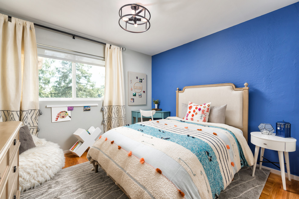 Diseño de dormitorio infantil tradicional renovado pequeño con paredes azules, suelo de madera en tonos medios y suelo marrón