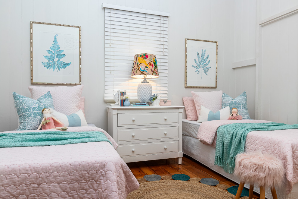 Immagine di una cameretta per bambini stile marino con pareti bianche, pavimento in legno massello medio, pavimento marrone e pareti in perlinato