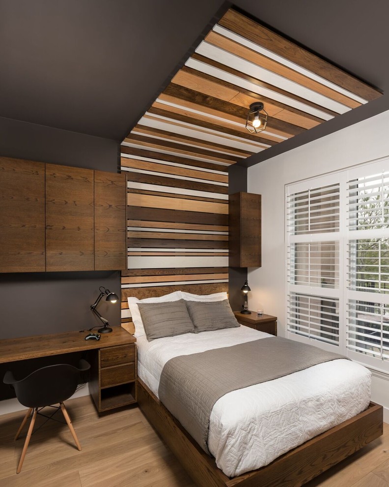Imagen de dormitorio infantil minimalista de tamaño medio con paredes multicolor, suelo de madera en tonos medios y suelo marrón