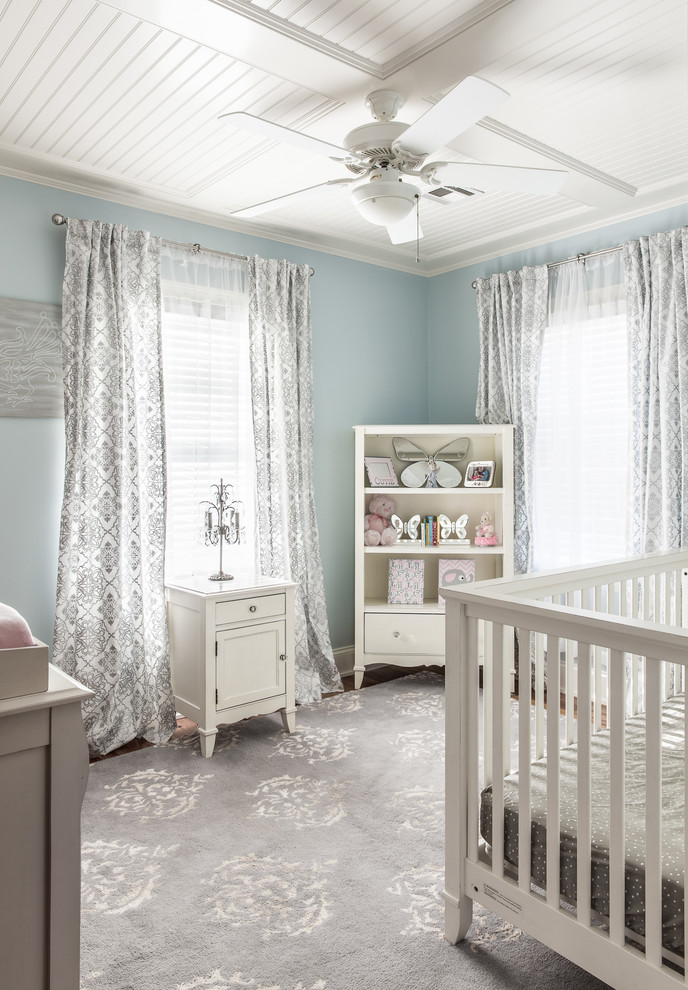 Cette image montre une chambre de bébé fille traditionnelle de taille moyenne avec un mur bleu et un sol en bois brun.