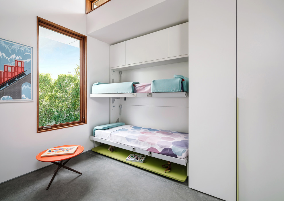 Esempio di una cameretta per bambini da 4 a 10 anni minimalista con pareti bianche, pavimento in cemento e pavimento grigio