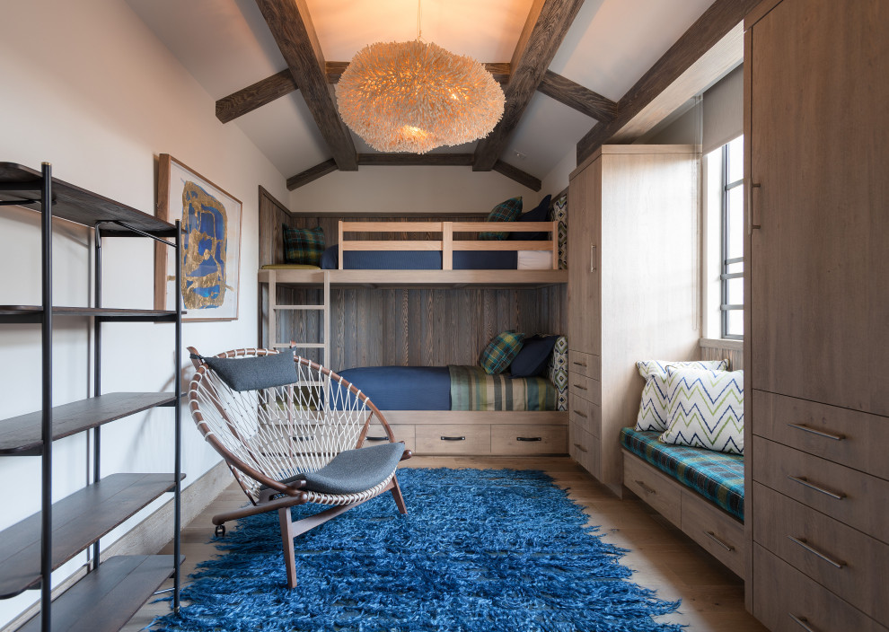 Large contemporary gender neutral children’s room in Orange County with medium hardwood flooring, white walls, beige floors and exposed beams.