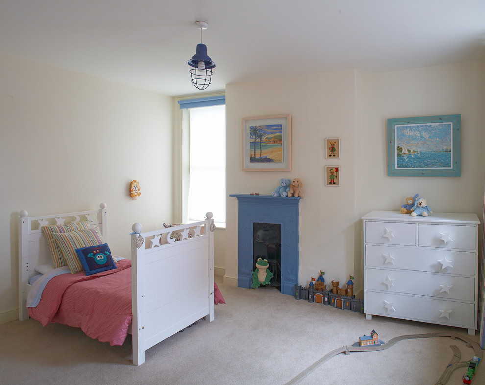 This is an example of a contemporary gender neutral toddler’s room in Dublin with beige walls, carpet and a chimney breast.